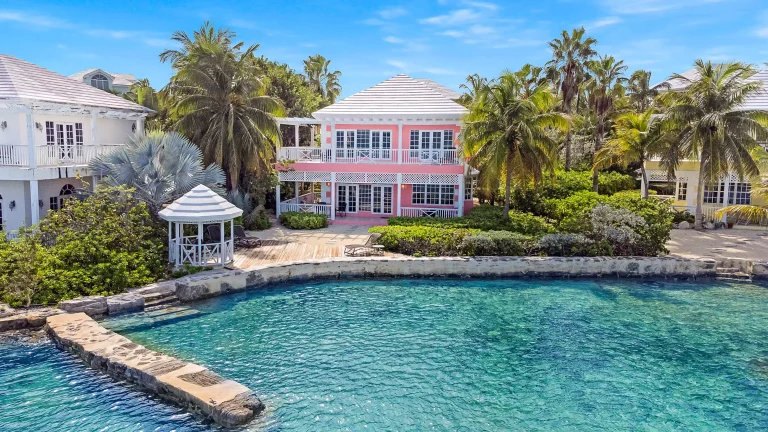 Pink house and pool among palms at Sea Star Villa, George Town, Great Exuma