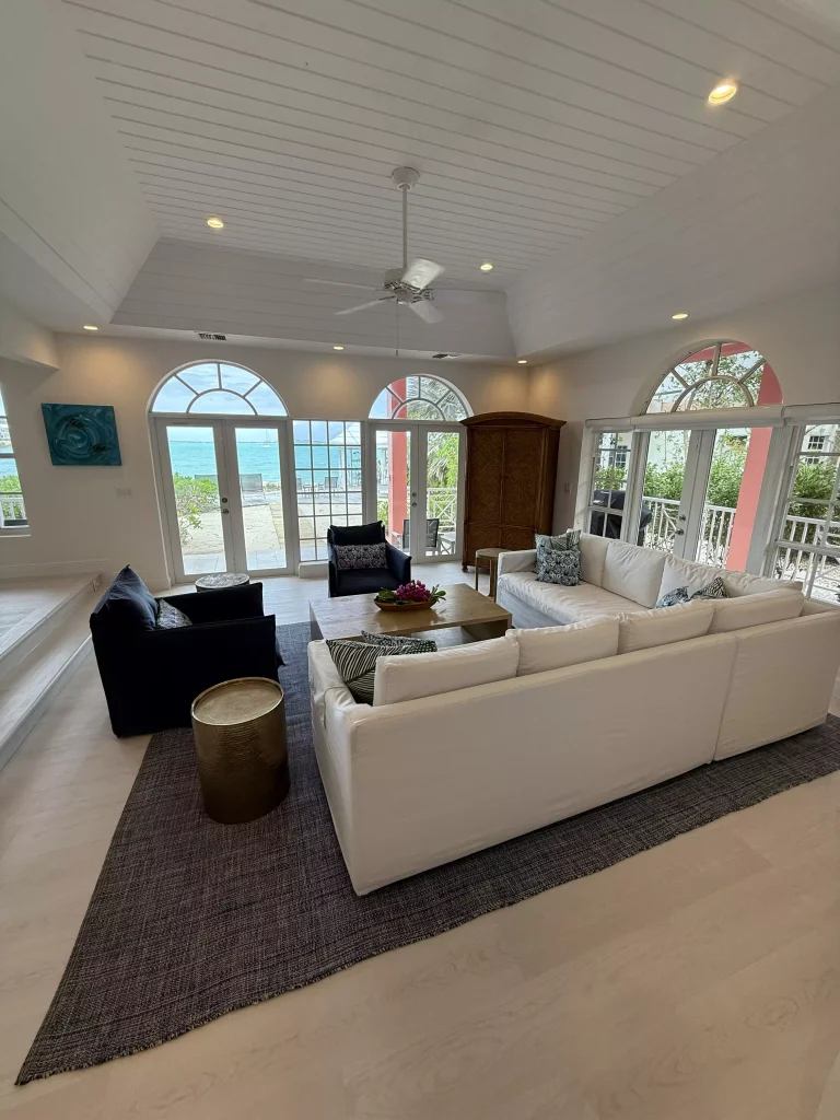 Living room with white sofa and arched windows at Sea Star Villa, George Town, Great Exuma
