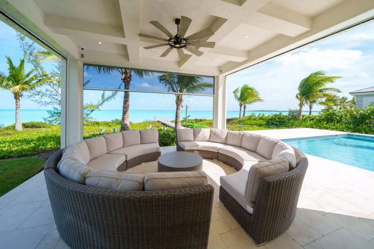Covered lounge with round sectional and pool view at Seaclusion, George Town, Great Exuma