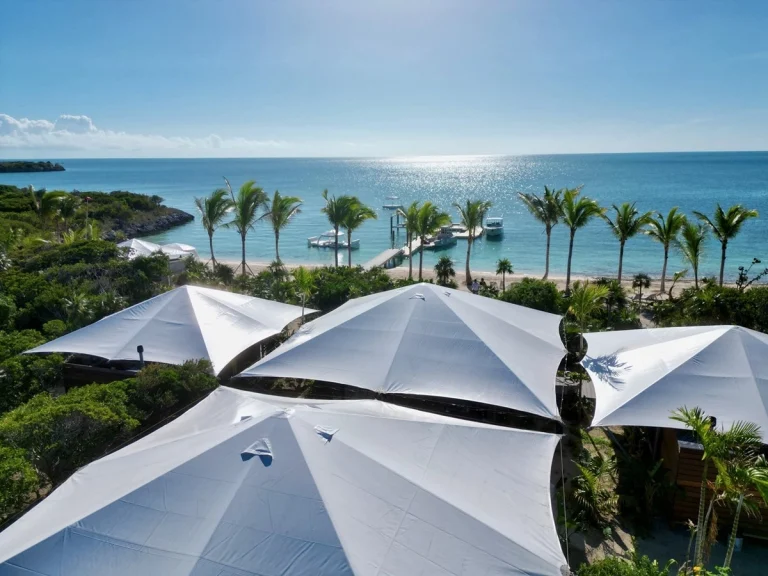 White umbrellas above the beach and ocean at Luxumas, Exuma Cays, Exuma