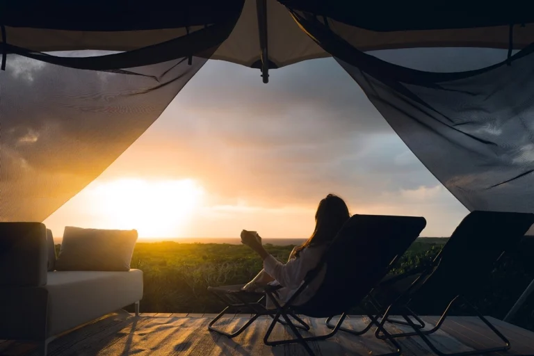 Guest relaxing under a canopy at sunset at Luxumas, Exuma Cays, Exuma