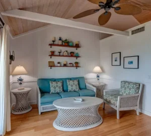 Sitting room with teal sofa and wood ceiling at Harbour View Cottage, Hope Town, Elbow Cay