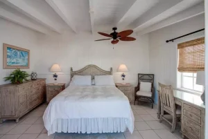 Bedroom with wooden headboard and desk at Harbour View Cottage, Hope Town, Elbow Cay