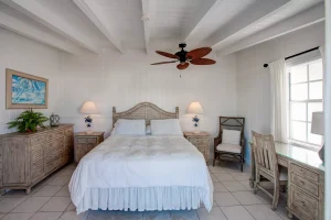 Bedroom with wooden headboard and desk at Ocean Side Rooms, Hope Town, Elbow Cay