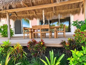 Outdoor dining table under a thatched roof at Sea Smoke Estate, Treasure Cay, Abaco